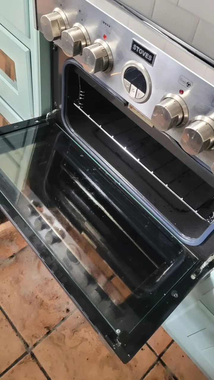 Freshly cleaned oven with a spotless glass door and racks