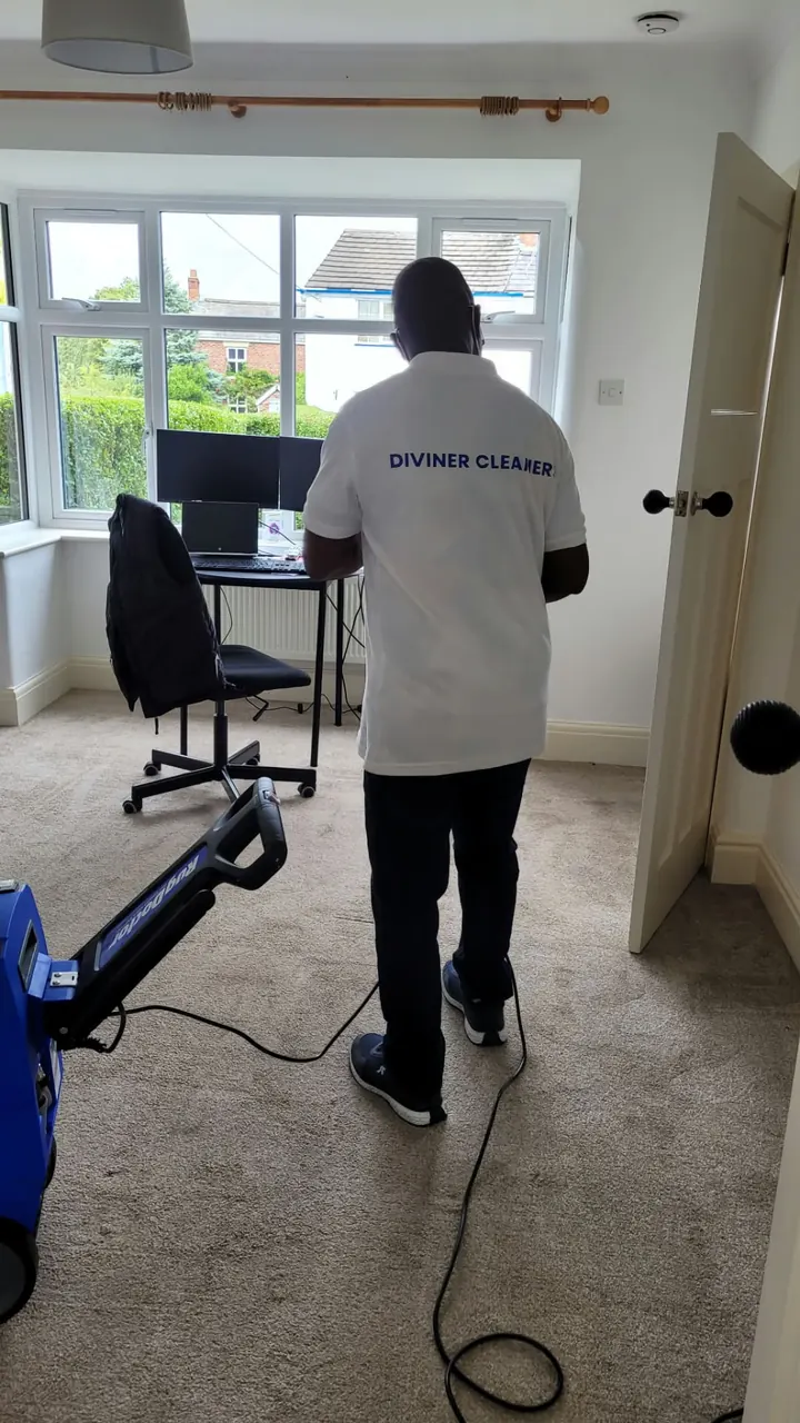 Diviner Cleaners team member cleaning the carpet in a home office